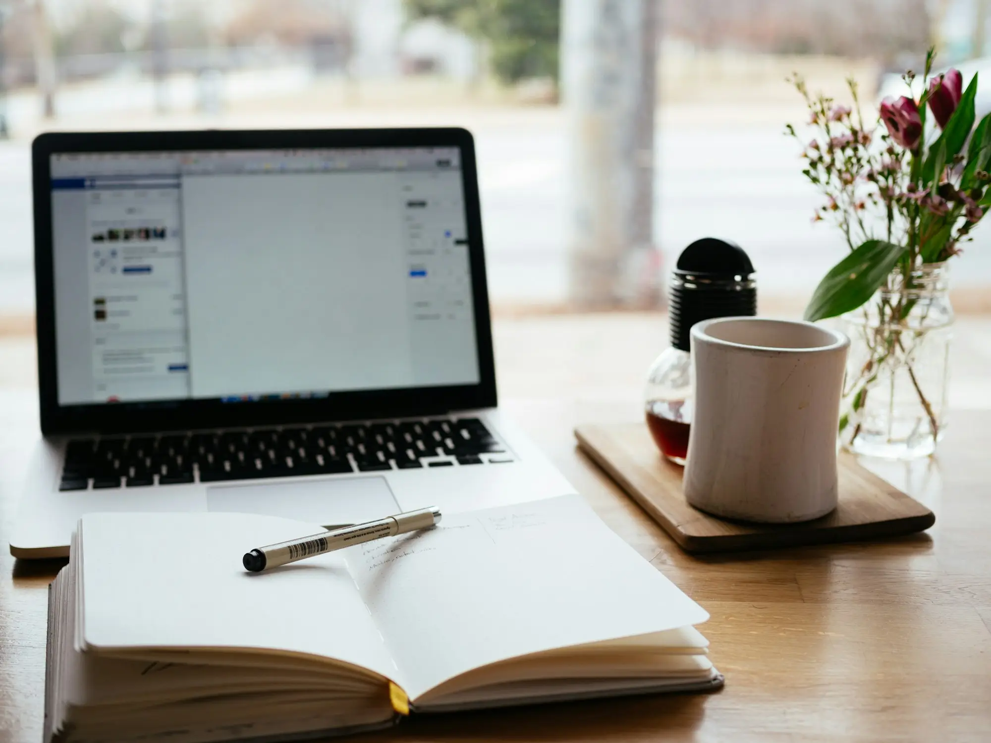 Laptop beside an open notebook